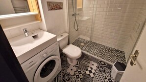 A compact bathroom with a washing machine, toilet, and shower. - 30m from ski slopes, 1st floor, view mountain, balcony, tv, ski locker, 42m², Valfréjus (Valfréjus)