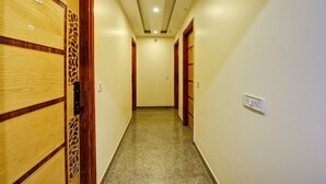A hallway with wooden doors, numbered 102, leading to rooms. - The York Legacy (New Delhi)