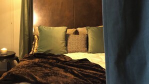 A bedroom with a bed, a bedside table, a lamp, and a curtain. - Penthouse _ 70' Suite Gallery with Panoramic Terrace (Roma)