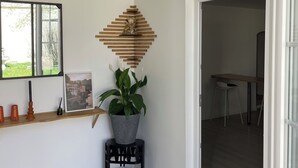 Un intérieur moderne avec une étagère en bois, une plante en pot et un tableau encadré au mur.