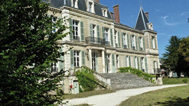 Un grand bâtiment historique doté de nombreuses fenêtres et d’un escalier imposant menant à l’entrée.