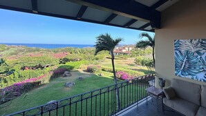 A balcony with a view of a lush garden and the ocean. - 2-bedroom condo in Reserva Conchal, best ocean view!!! (Playa conchal)