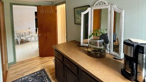 A kitchen with a wooden countertop, a coffee maker, and a decorative jar.