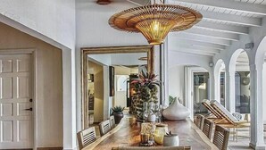 A spacious dining area with a long wooden table, multiple chairs, and a central hanging light fixture. - NEW LISTING: Hidden Pearl Luxurious Villa - Ocean View (Philipsburg)
