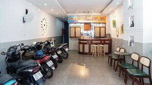 A hotel reception area with a sign reading "You & Me Welcome To Vung Tau Hotel."