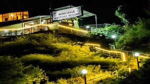 A nighttime view of a resort with a sign reading "Aurevelle Kastura Resort." - AUREVELLE KASTURA RESORT KANATAL (Kanatal)