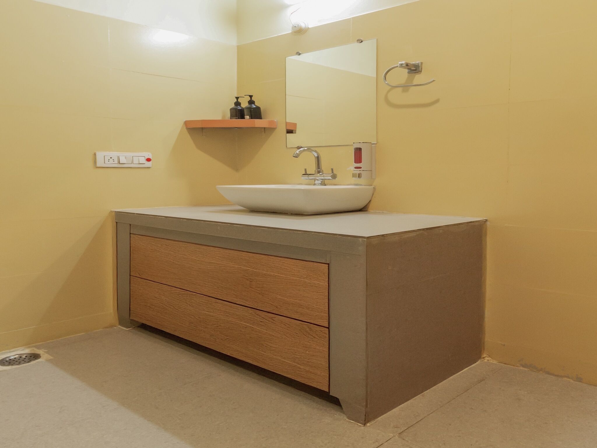 A bathroom with a white sink, a mirror, a wooden cabinet, and a towel rack.