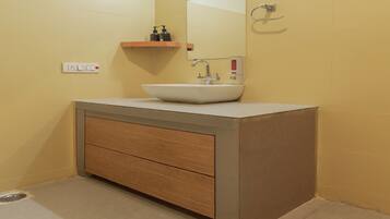 A bathroom with a white sink, a mirror, a wooden cabinet, and a towel rack.