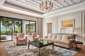 A spacious living room with a large window, a chandelier, and a painting on the wall.