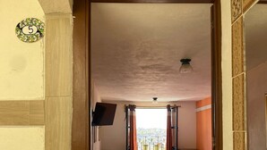 A hotel room with a bed, a desk, and a TV. - Casa 12 Reales (Guanajuato)