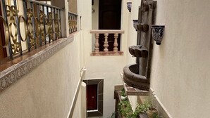 A narrow, tiled staircase with a decorative railing, leading to a door at the top. - Casa 12 Reales (Guanajuato)