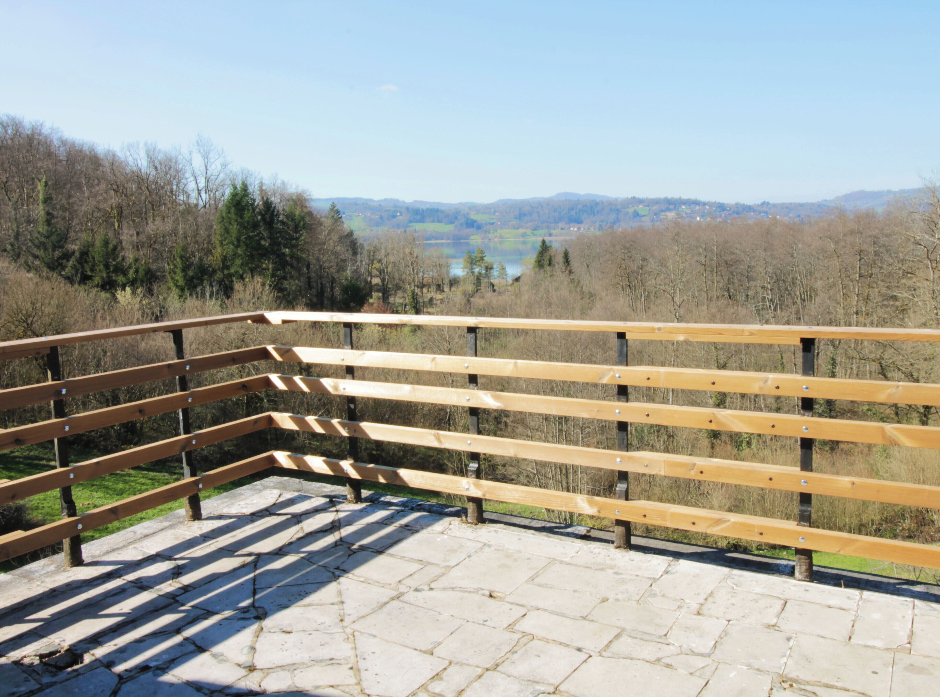 Un banc en bois situé près d’une zone dallée de pierres dans un parc.