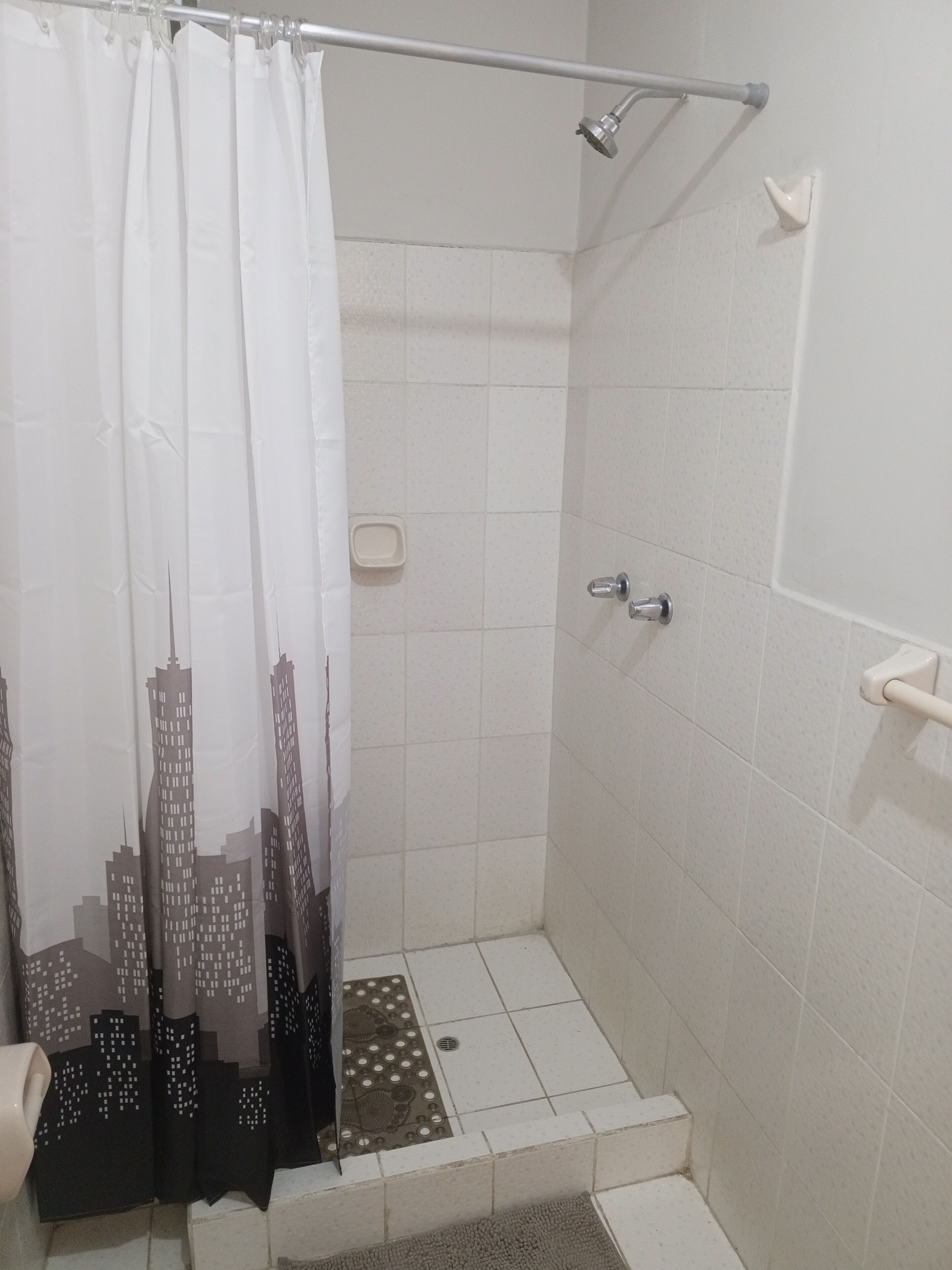 Een douche, handdoeken, toiletpapier