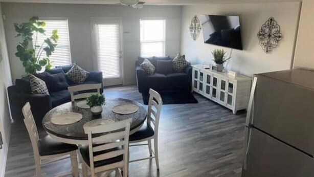 A living room with a dining table, two sofas, a TV, and a cabinet. - New Home w/Patio near Laughlin/Mohave/Colorado Riv (Bullhead City)