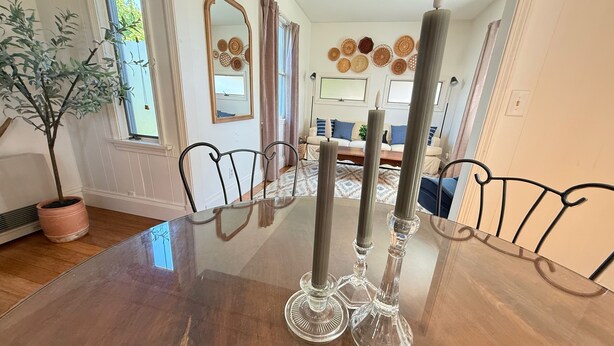 Una mesa de comedor con sillas, una planta en maceta y objetos decorativos.