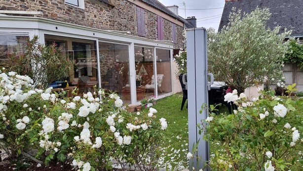A conservatory with a stone exterior, a glass door, and a garden with white roses. - KERYVONNE, FAMILY HOME (Sarzeau)