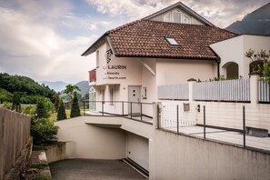 Una villa con techo de tejas, un balcón y vistas del paisaje circundante.