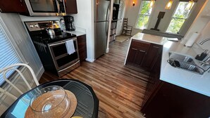 Una cocina moderna con una isla central, electrodomésticos de acero inoxidable y vistas al exterior.