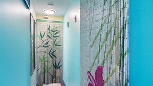 A hallway with bamboo-style wall decorations and a patterned rug. - Oceanfront charming 2 bedroom 30 second walk to the beach (Seaside Heights)
