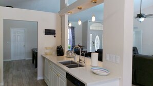 A modern kitchen with a dishwasher, sink, and a large mirror above the countertop. - Villa Varona, Private Heated Pool Included- No extra fee (Lake Placid)
