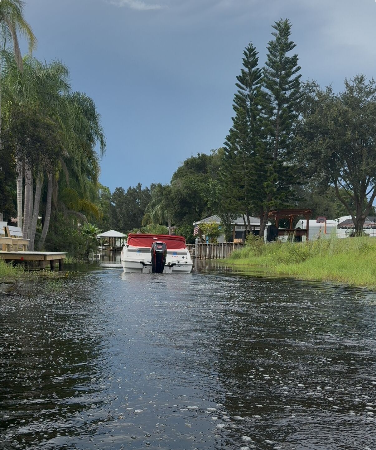 A boat on a narrow waterway with houses on either side.
