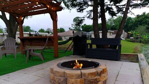 A fire pit surrounded by stone, a wooden pergola, and outdoor furniture. - Villa Varona, Private Heated Pool Included- No extra fee (Lake Placid)
