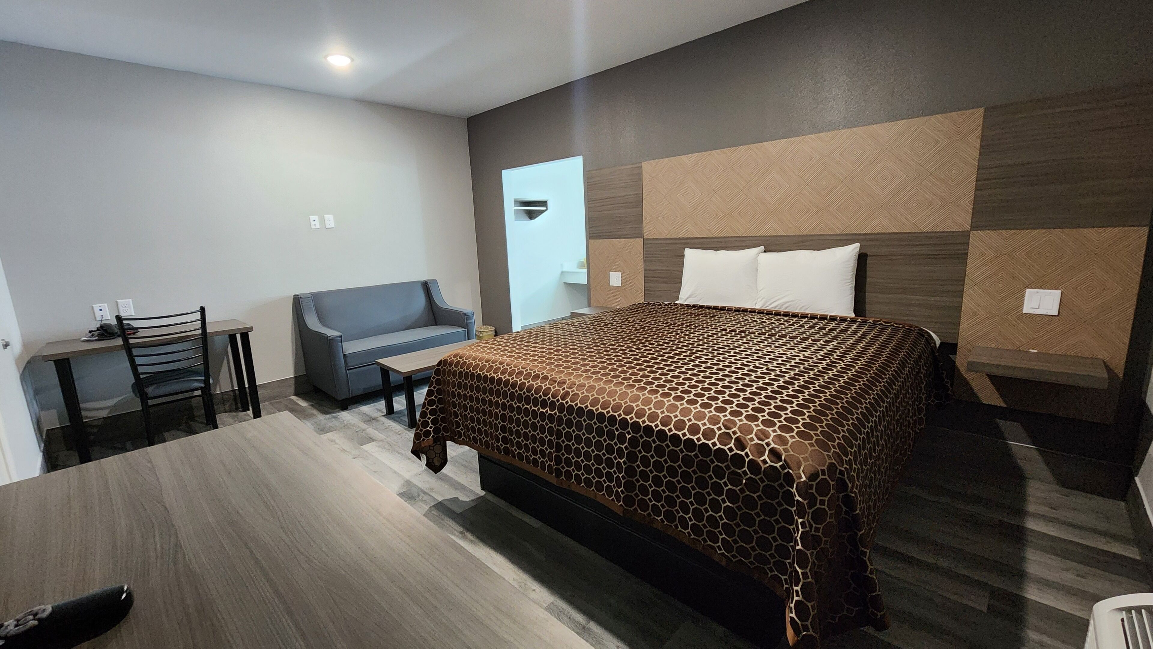Une chambre d’hôtel avec un grand lit, un bureau, une chaise et un canapé.