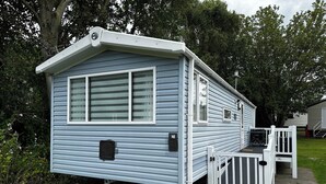 A mobile home with a front porch, a ramp, and a small deck. - Tranquil Caravan Retreat by the Seaside, Portseton (Prestonpans)