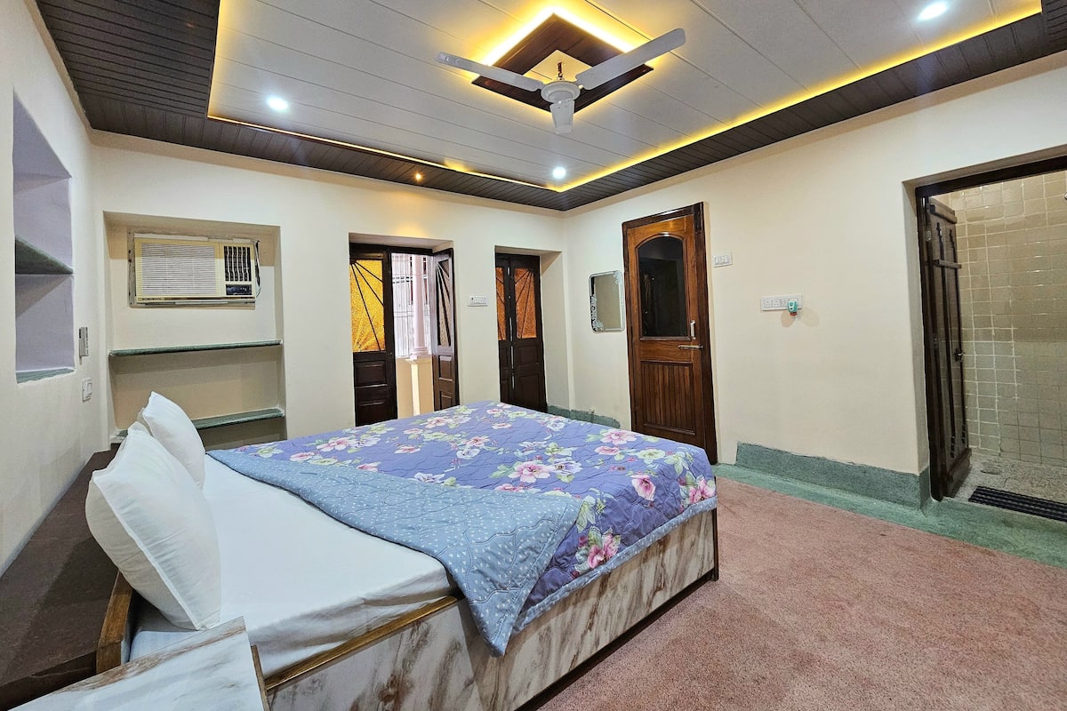 A bedroom with a bed, a ceiling fan, and a window with blinds.