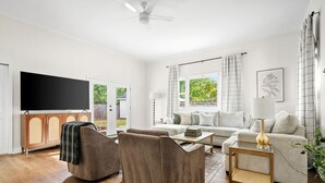 A spacious living room with a sofa set, a coffee table, and a TV.