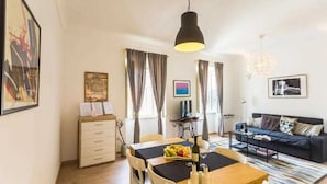 Una sala de estar moderna con comedor, un sofá y un televisor.