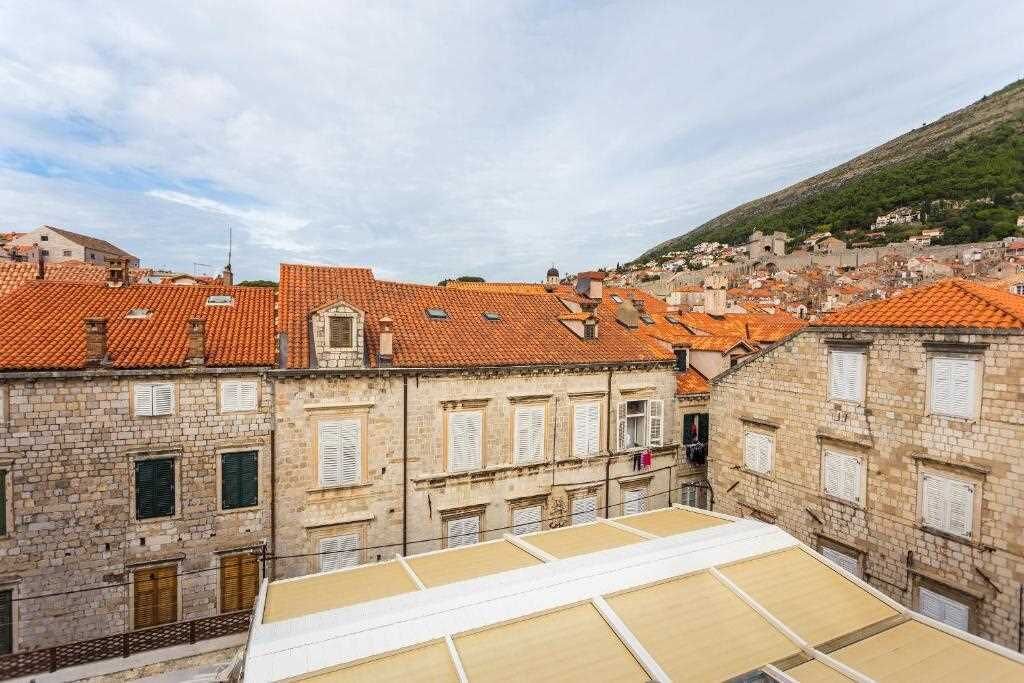 A view of a historic town with terracotta-tiled rooftops and stone buildings.