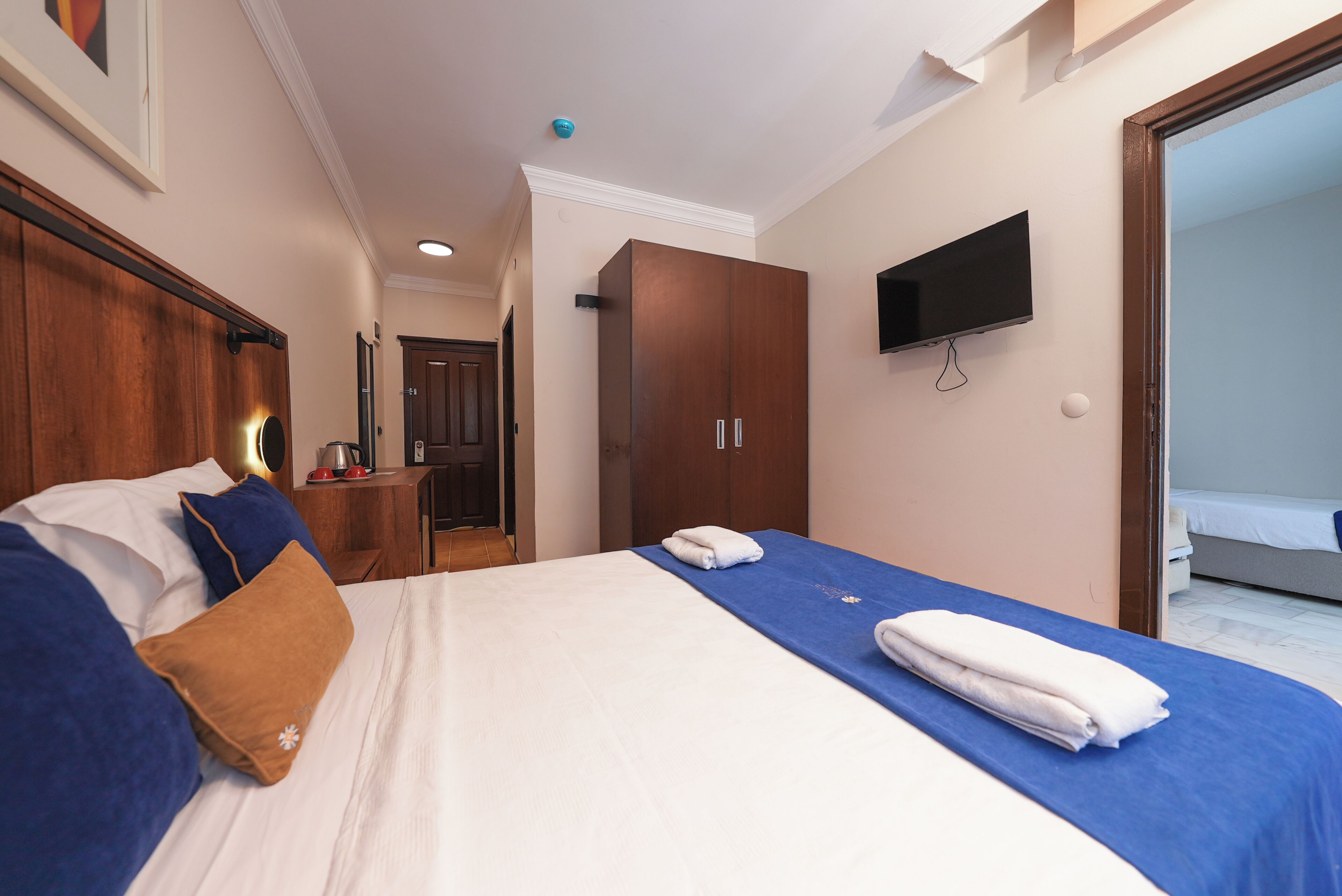 Une chambre d’hôtel avec un lit, une télévision, une armoire et une salle de bain.