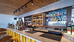 A bar with a wooden ceiling, shelves of liquor bottles, and bar stools. - The Lume Boutique Hotel & Restaurant & Spa (Bodrum)
