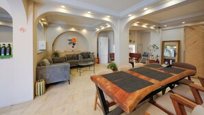 A spacious living area with a large wooden dining table, sofas, and a kitchen in the background. - The Lume Boutique Hotel & Restaurant & Spa (Bodrum)