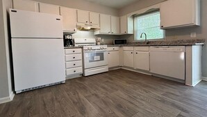 A kitchen with white cabinets, a refrigerator, stove, microwave, and dishwasher. - Stockbridge Quiet Hideaway (Stockbridge)