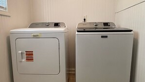 Two white Maytag appliances, a front-loading washer and a top-loading dryer, in a corner of a room with beige walls and tiled flooring. - Stockbridge Quiet Hideaway (Stockbridge)