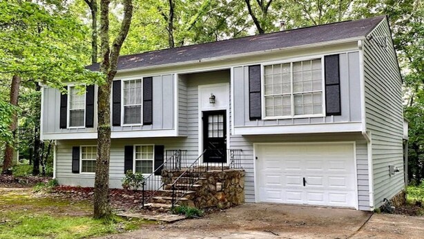 A two-story house with a garage, a front door, and a small front porch with steps. - Stockbridge Quiet Hideaway (Stockbridge)