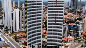Dos edificios altos con un patio central, rodeados de calles y otros edificios.