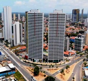 Two high-rise buildings with a central courtyard, surrounded by roads and other buildings. - CJC Short Stay D'Barcane (Natal)