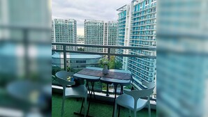 Un balcón con mesa y sillas, con vistas a edificios altos.