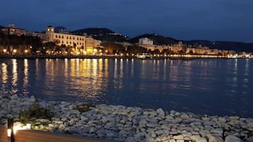 A waterfront promenade with a stone balustrade and a wooden deck.