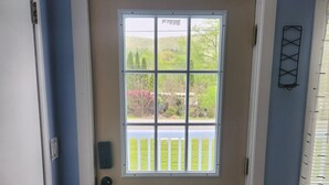 Une porte d’entrée avec une fenêtre, un carillon et une boîte aux lettres.