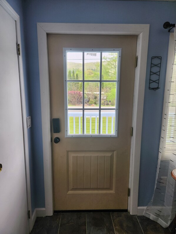 Puerta principal con ventana, timbre y buzón.