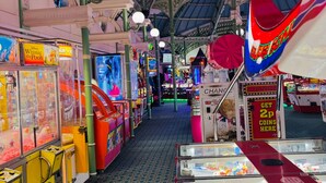 An arcade with various gaming machines, including claw machines and arcade games. - Traditional English House (Brighton and Hove)