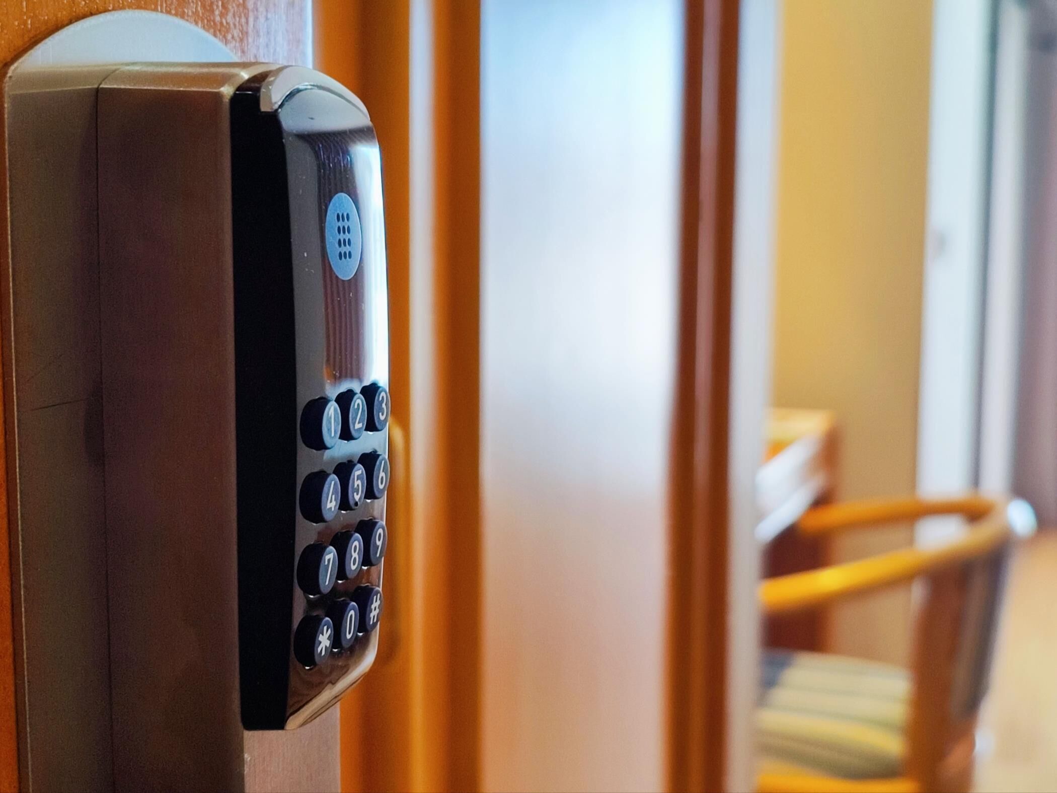 A keypad lock on a wooden door, likely for a hotel room.