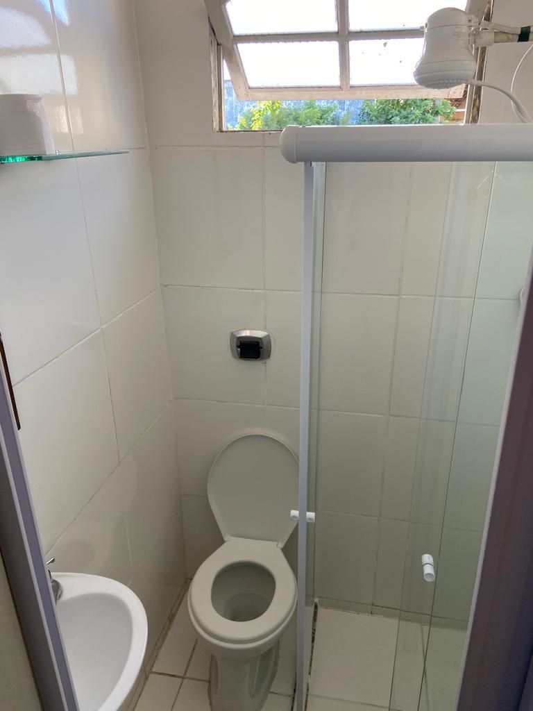A small, tiled bathroom with a toilet, bidet, and shower.