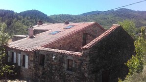 A stone building with a red-tiled roof, multiple chimneys, and a small window. - Entre Eaux et Roches - 5-person gite in character Ardèche house (Beaumont)