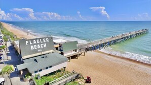 A beach with a pier, a building labeled "FLAGLER BEACH FLA", and a parking lot. - Private Pool 4BR | Sleeps 10 + Near Beach (Palm Coast)