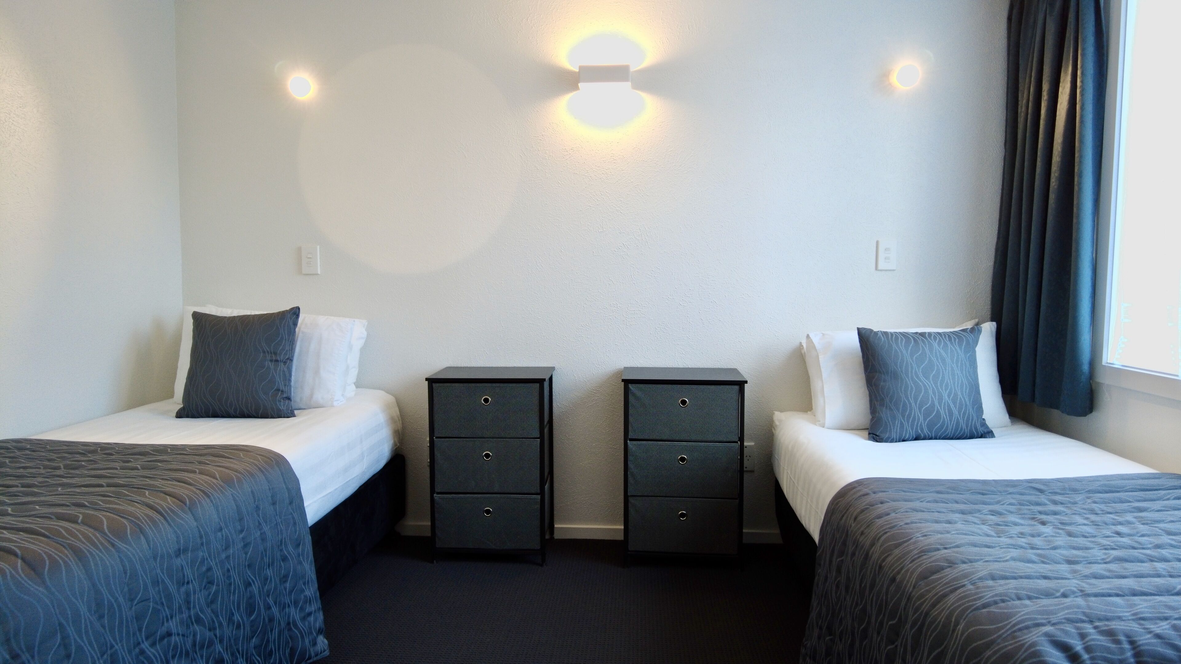 Ein Hotelzimmer mit zwei Betten, jeweils mit Kissen und einem Nachttisch.